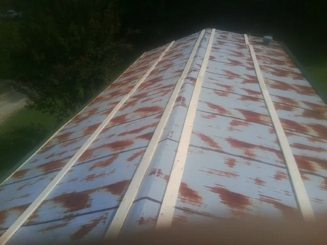 Rusted metal roof panels with new wood purlins before replacement — Storm Damage Roof Repair in Oak Hill by Roofing Brothers